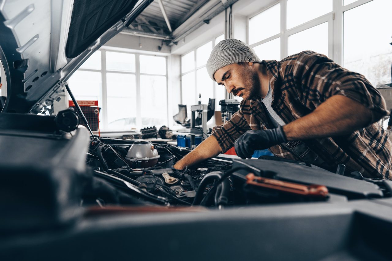 Mechanic testing a car battery with a diagnostic tool