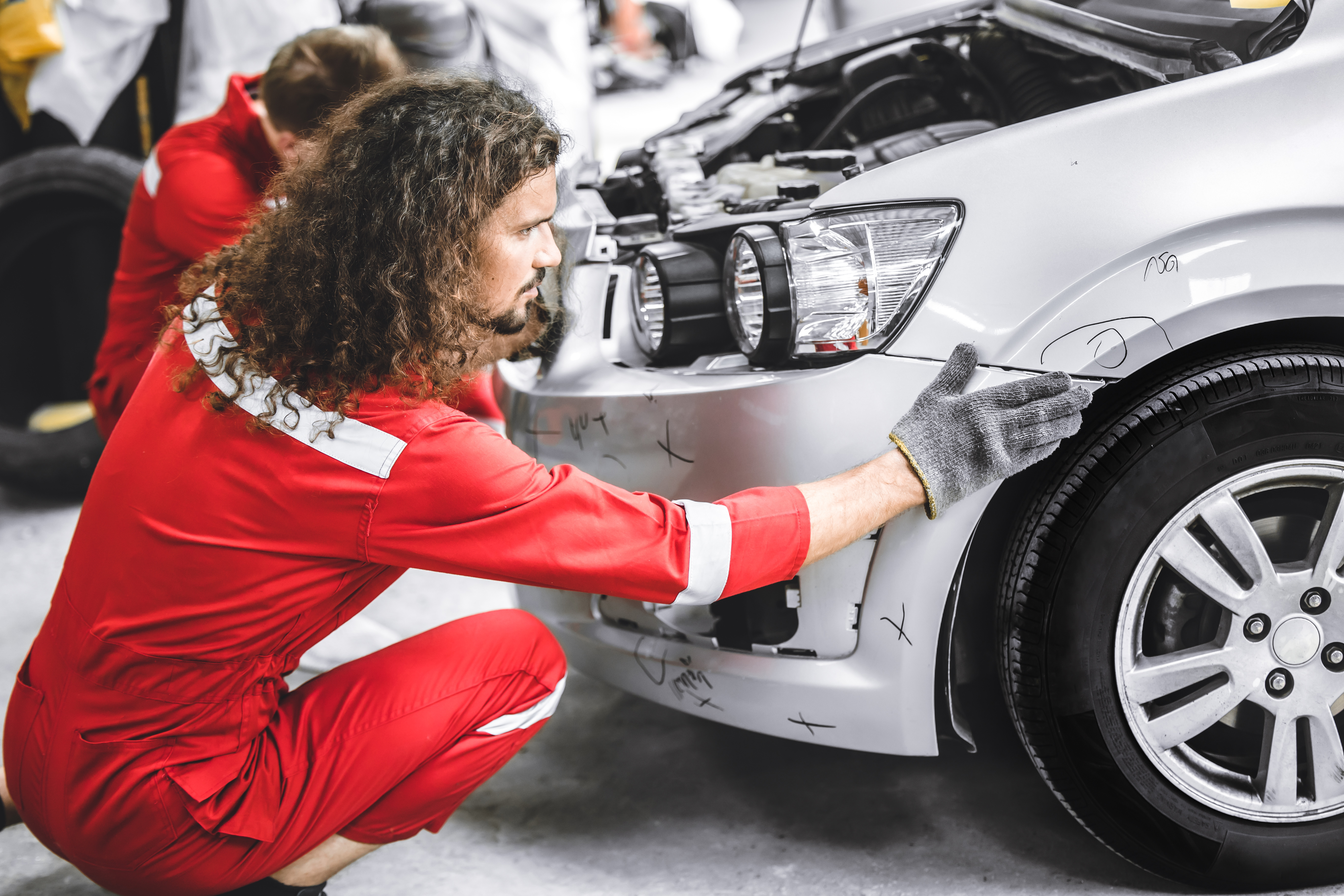 Technician repairing a damaged front bumper