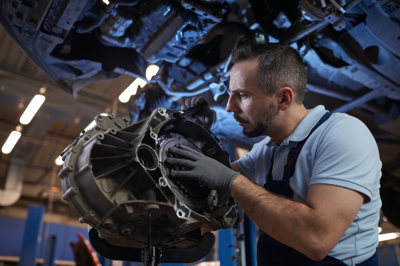 Mechanic working under the hood of a stalled car