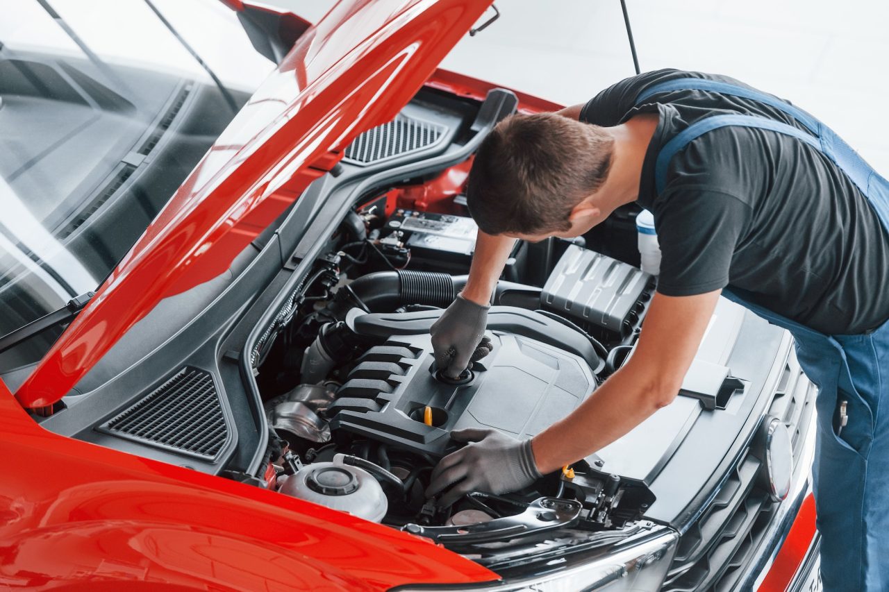 Technician touching up a scratch on a car door panel